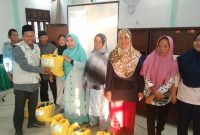 Ketua Lazisnu Kabupaten Melawi, Ustadz M. Yusuf menyerahkan paket sembako kepada mustahiq bernama Ibu Eka dalam acara Festival Ramadhan bertajuk Kolaborasi Sejuta Cinta di Aula Kantor Kementerian Agama Kabupaten Melawi.