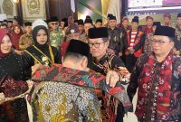 Ketua Majelis Kehormatan IKBM Kalbar H. Mahalli Ilyas Mengalungkan Selendang dan Memakaikan Odheng Kepada Gubernur Kalbar 